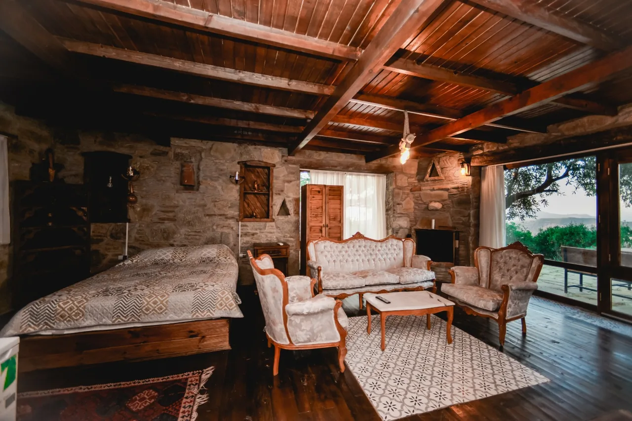 Kayalı House's stone walls, wooden ceiling and light-coloured seating area