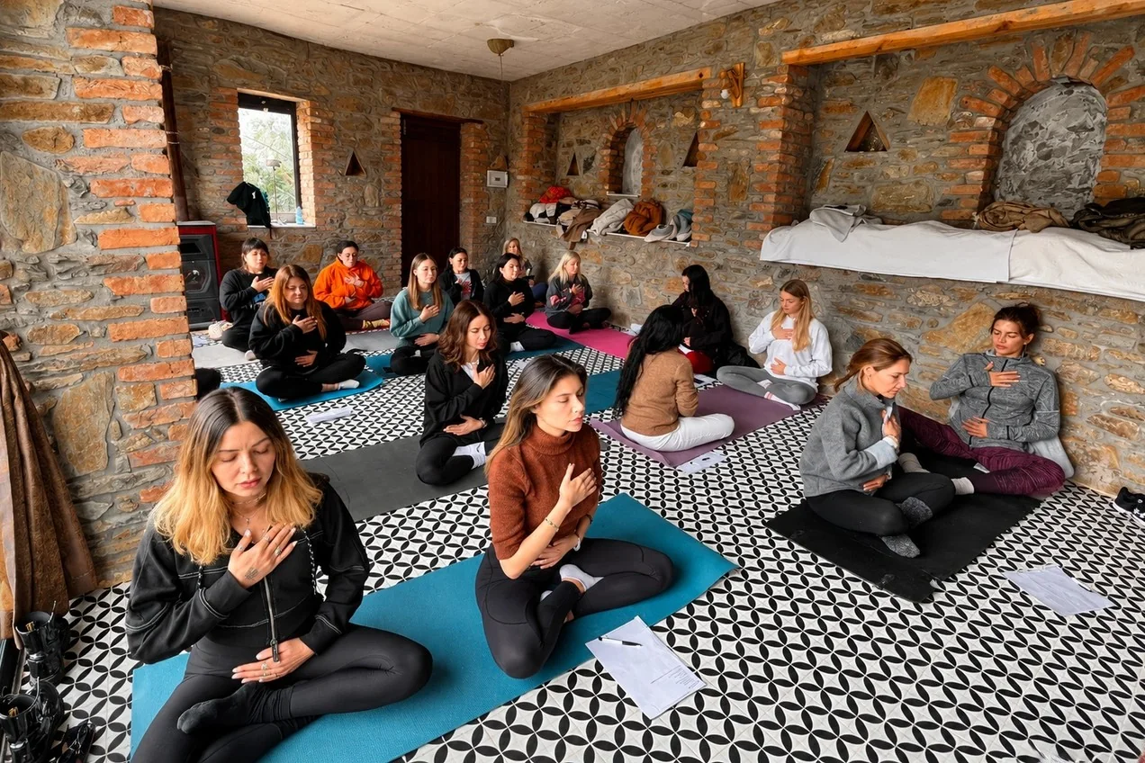Kırkınca'nın taş duvarlı salonunda matlarda oturan yoga katılımcıları